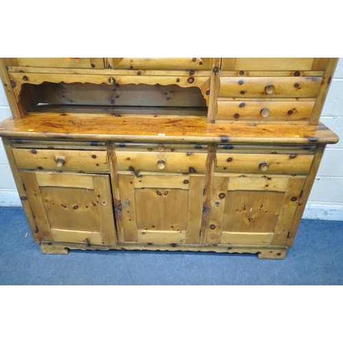 1312 - A PINE DRESSER, the top made up in an arrangement of drawers and cupboard, above a base with three d... 