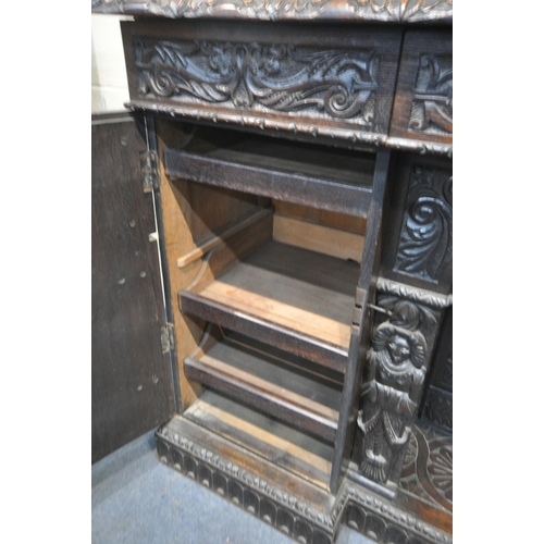 1327 - A 19TH CENTURY HEAVILY CARVED OAK SIDEBOARD, the raised back with panelling and shelf, fitted with t... 