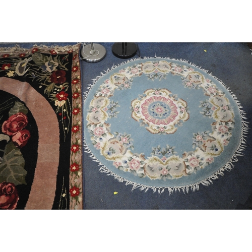 1335 - A WOOLLEN FLORAL RUG, on a black ground, 248cm x 168cm, along with a Chinese blue circular rug, and ... 