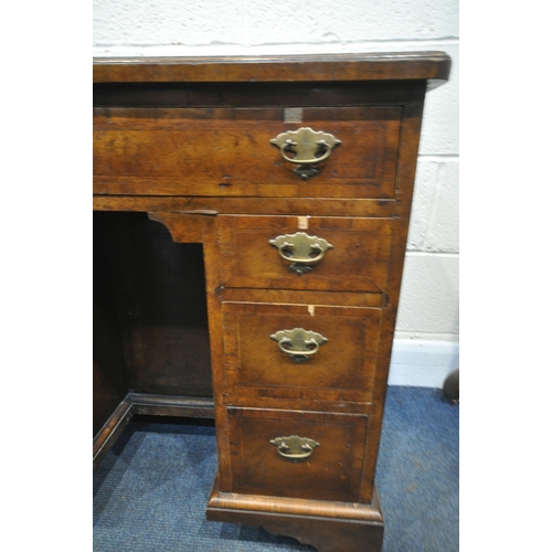 1340 - A REPRODUCTION GEORGIAN STYLE WALNUT KNEE HOLE DESK, the quarter veneer top, over an arrangement of ... 