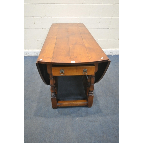 1347 - A GOOD QUALITY LARGE REPRODUCTION ELM DROP LEAF TABLE, with a single frieze drawer to each end, rais... 