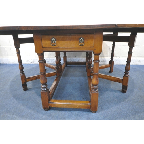 1347 - A GOOD QUALITY LARGE REPRODUCTION ELM DROP LEAF TABLE, with a single frieze drawer to each end, rais... 