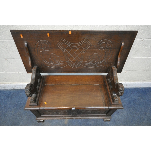 1349 - AN EARLY 20TH CENTURY OAK MONKS BENCH, with a rise and fall backrest / surface, lion armrests and a ... 