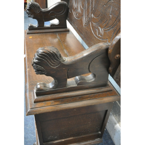 1349 - AN EARLY 20TH CENTURY OAK MONKS BENCH, with a rise and fall backrest / surface, lion armrests and a ... 