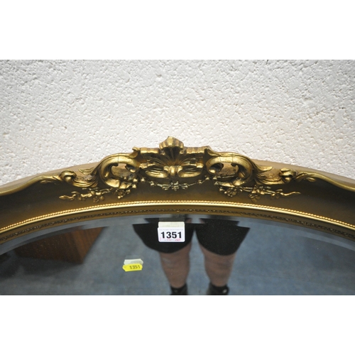 1351 - A GILT RESIN OVAL BEVELLED EDGE WALL MIRROR, with foliate details, 90cm x 69cm, a Regency style conv... 