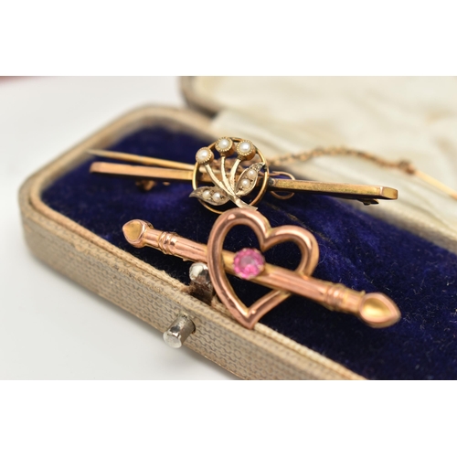 10 - TWO EARLY 20TH CENTURY BROOCHES, the first an open work heart with bar set with a single pink paste ... 