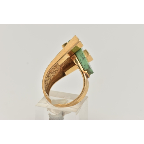 53 - A YELLOW METAL GEM SET DRESS RING, designed with a tapered slice of green hardstone, between two pol... 