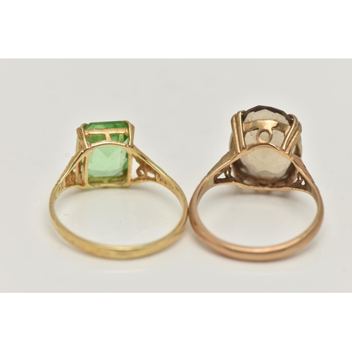 55 - TWO YELLOW METAL GEM SET RINGS, the first set with an oval cut smoky quartz, in a double four claw s... 