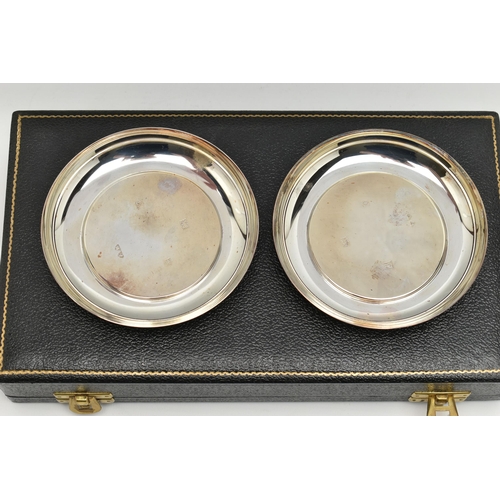 190 - A CASED PAIR OF ELIZABETH II SILVER CIRCULAR PIN TRAYS, plain with hallmarks to the interior, maker ... 