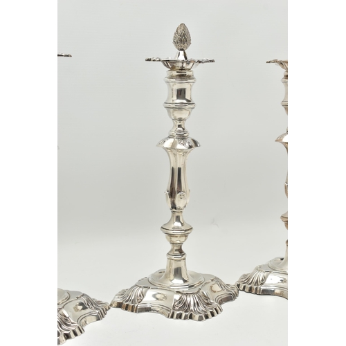 193 - A GEORGE V SILVER SET OF FOUR CANDLESTICKS  IN GEORGE II STYLE, with removable shaped square drip pa... 