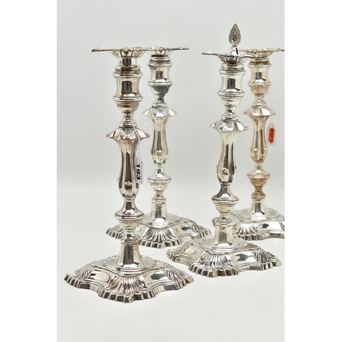 193 - A GEORGE V SILVER SET OF FOUR CANDLESTICKS  IN GEORGE II STYLE, with removable shaped square drip pa... 