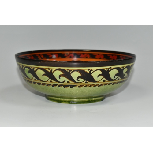 328 - A PILKINGTON'S BOWL, decorated with flowers and foliage on a mid-green exterior and a red/orange int... 