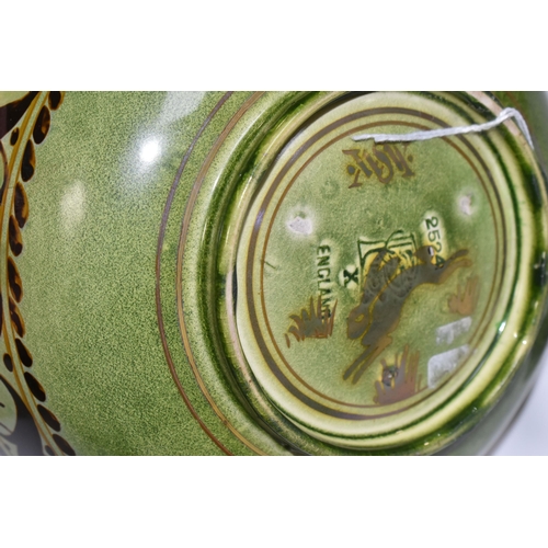 328 - A PILKINGTON'S BOWL, decorated with flowers and foliage on a mid-green exterior and a red/orange int... 