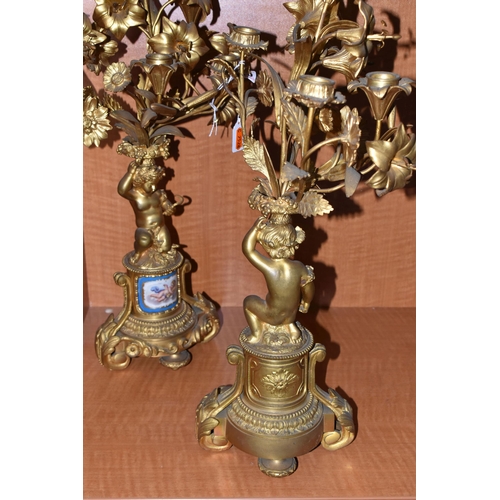 710 - A PAIR OF MID 19TH GILT METAL candelabra, the upper section of floral form fitted with candle holder... 