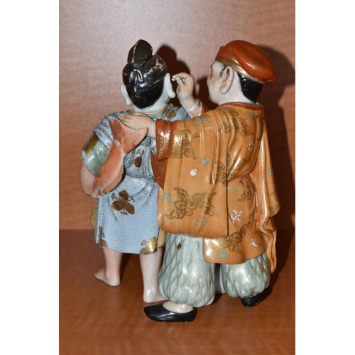 732 - A LATE 19TH / EARLY 20TH CENTURY JAPANESE PORCELAIN FIGURE GROUP OF TWO MEN, one holding a carp and ... 