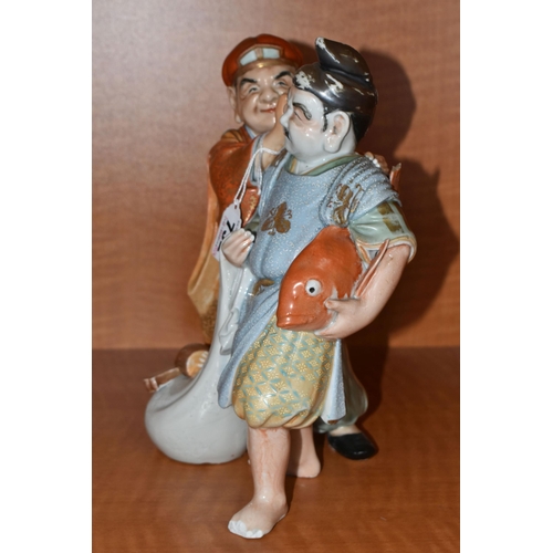 732 - A LATE 19TH / EARLY 20TH CENTURY JAPANESE PORCELAIN FIGURE GROUP OF TWO MEN, one holding a carp and ... 