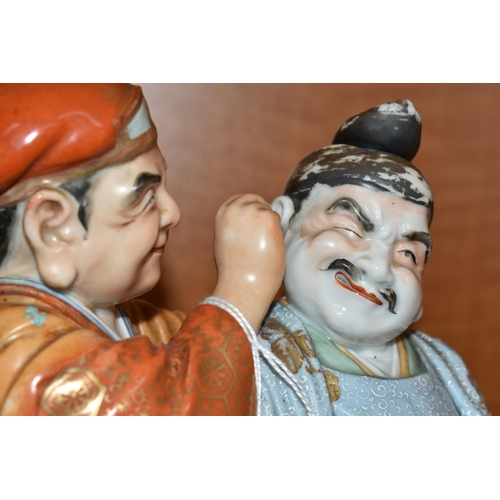 732 - A LATE 19TH / EARLY 20TH CENTURY JAPANESE PORCELAIN FIGURE GROUP OF TWO MEN, one holding a carp and ... 