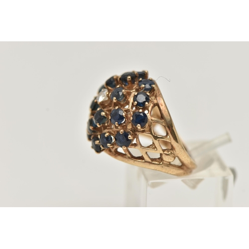 7 - A 9CT GOLD SAPPHIRE AND DIAMOND BOMBE RING, twenty circular cut sapphires and a single round brillia... 