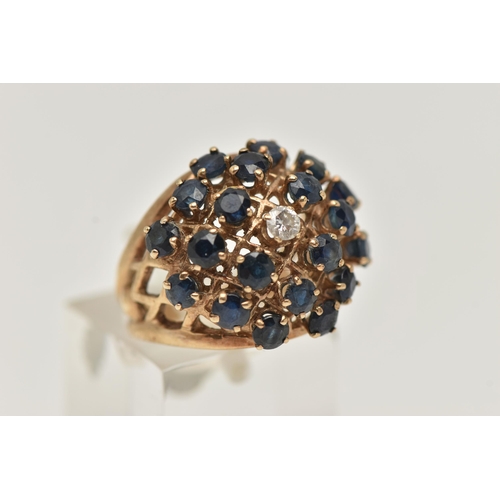 7 - A 9CT GOLD SAPPHIRE AND DIAMOND BOMBE RING, twenty circular cut sapphires and a single round brillia... 