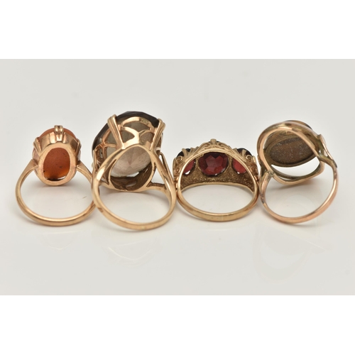 8 - FOUR GEM SET RINGS, to include a large oval cut smoky quartz, approximate length 22mm, prong set in ... 