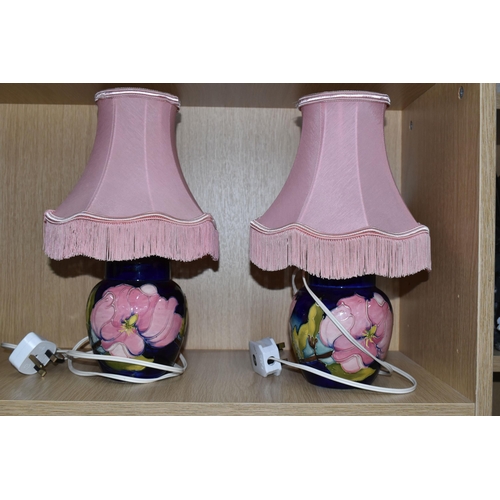 383 - A PAIR OF MOORCROFT POTTERY CONVERTED GINGER JAR TABLE LAMPS, tube lined in the Magnolia pattern on ... 