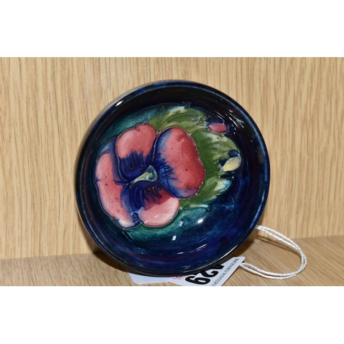 430 - A MOORCROFT POTTERY 'PANSY' SMALL FOOTED BOWL, tube lined with a pink and purple Pansy on a dark blu... 