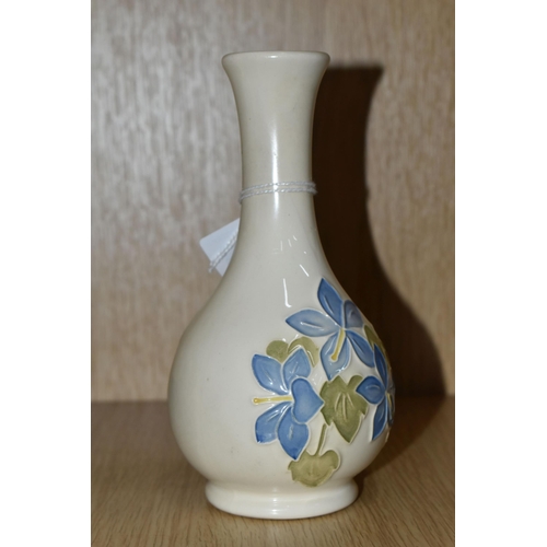 436 - A MOORCROFT POTTERY 'BLUE CAMPANULA' BUD VASE, tube lined with pale blue campanula flowers on a crea... 