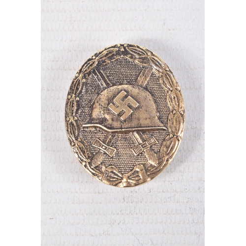 384 - A GOLD GERMAN WOUND BADGE AND A NARVIK SHIELD, the wound badge has a vertical pin on the rear but no... 