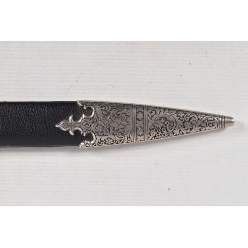 397 - A DECORATIVE DAGGER WITH A CARVED HANDLE WITH EMBOSSED BLADE, this comes in a metal banded leather s... 