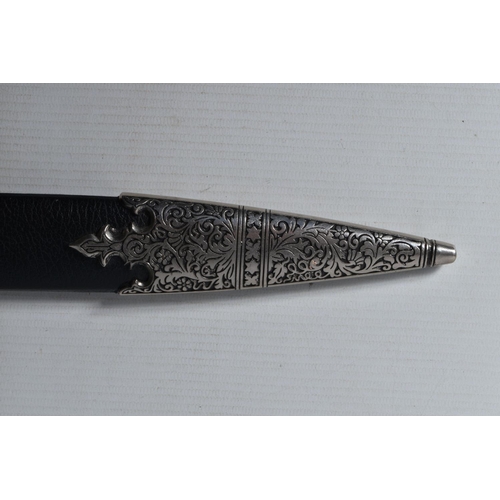 397 - A DECORATIVE DAGGER WITH A CARVED HANDLE WITH EMBOSSED BLADE, this comes in a metal banded leather s... 