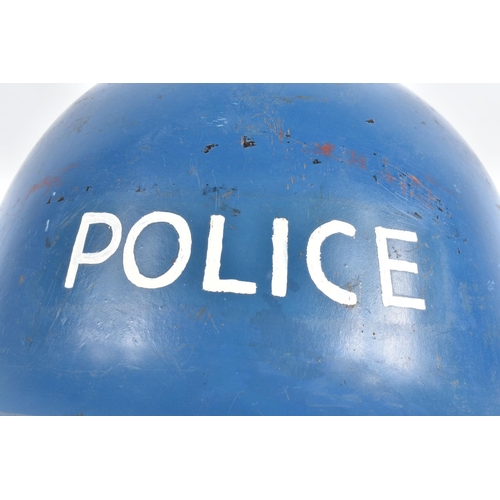 415 - A WWII ERA POLICE STEEL HELMET AND THREE OTHERS, the blue police helmet has a liner and chinestrap s... 