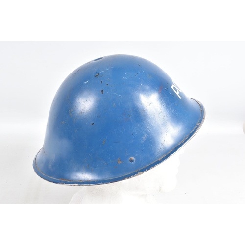 415 - A WWII ERA POLICE STEEL HELMET AND THREE OTHERS, the blue police helmet has a liner and chinestrap s... 