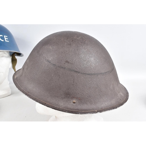 415 - A WWII ERA POLICE STEEL HELMET AND THREE OTHERS, the blue police helmet has a liner and chinestrap s... 