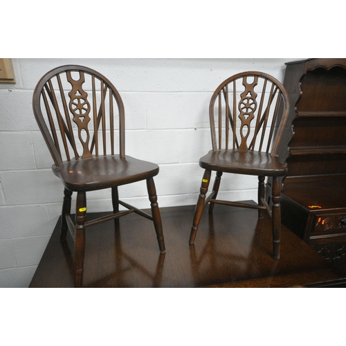 1220 - AN EARLY 20TH CENTURY OAK SIX PIECE DINING SUITE, comprising a draw leaf table, raised on trestle le... 