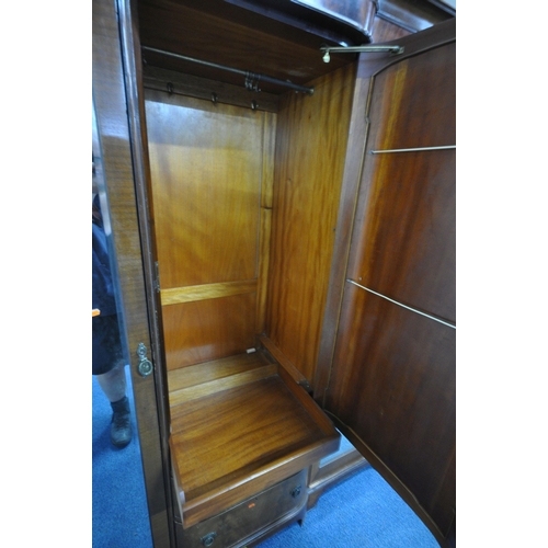 1243 - A REPRODUCTION MAHOGANY COMPACTUM WARDROBE, fitted with double bevelled mirrored doors, flanking a s... 