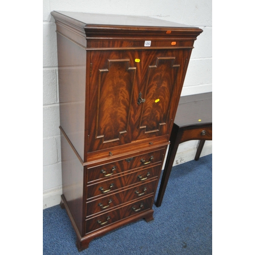 1252 - A REPRODUCTION MAHOGANY BRADLEY COCKTAIL CABINET, fitted with double doors, a brushing slide, above ... 