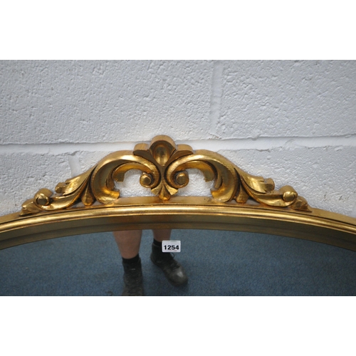 1254 - A LARGE GILT FRAMED ARCHED OVERMANTEL MIRROR, with scrolled details, width 140cm x height 111cm (con... 