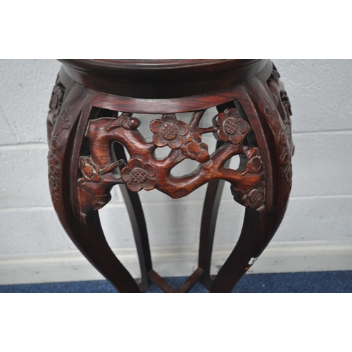 1257 - A REPRODUCTION STAINED HARDWOOD ORIENTAL PLANT STAND, with a marble insert, foliate details, raised ... 