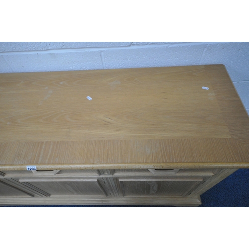 1269 - A BLONDE OAK SIDEBOARD, fitted with three drawers, above three push to open cupboard doors, length 1... 