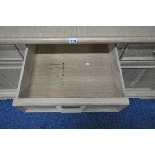 1269 - A BLONDE OAK SIDEBOARD, fitted with three drawers, above three push to open cupboard doors, length 1... 