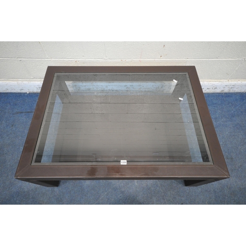 1335 - A LARGE RECTANGULAR LEATHERETTE COFFEE TABLE, with a bevelled glass insert, width 110cm x depth 80cm... 