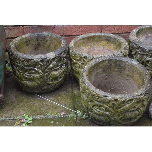 1010 - A SET OF FOUR WEATHERED COMPOSITE PLANTERS, diameter 32cm x height 24cm, along with a composite bird... 