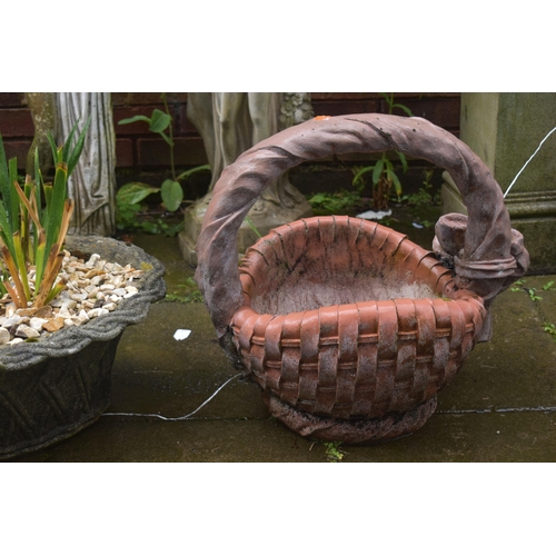 1015 - A TERRACOTTA COLOURED COMPOSITE PLANTER, in the shape of a woven basket, along with a weathered oval... 