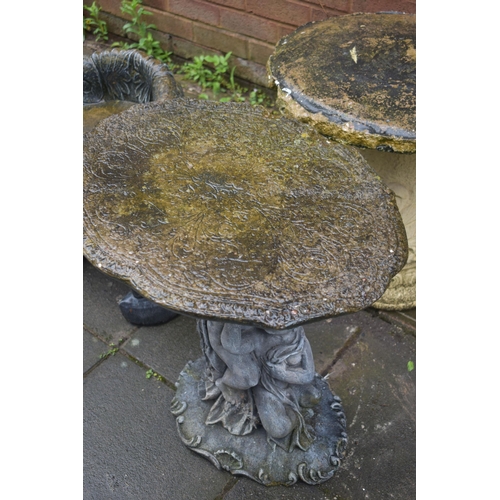 1023 - A CREAM COMPOSITE GARDEN TABLE, on a separate foliate base, diameter 51cm, along with a grey composi... 