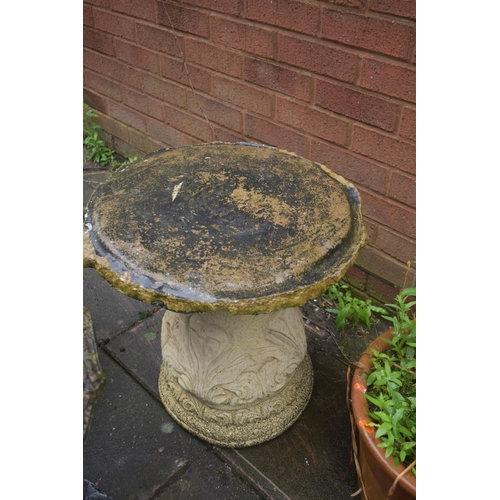 1023 - A CREAM COMPOSITE GARDEN TABLE, on a separate foliate base, diameter 51cm, along with a grey composi... 