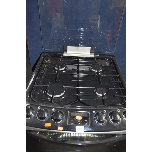 1086 - A ZANUSSI GAS COOKER with lift up glass lid concealing four gas rings over a grill and oven width 55... 