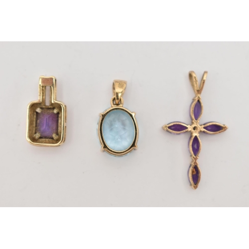 16 - THREE 9CT GOLD GEM PENDANTS, to include an oval claw set topaz, an amethyst and diamond set cross, a... 