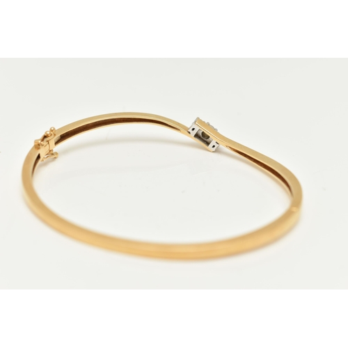 22 - AN 18CT GOLD DIAMOND HINGED BANGLE, a polished bangle of cross over design, set with three round bri... 