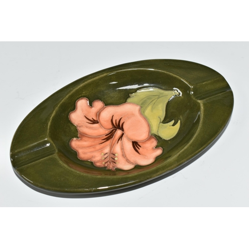 376 - A MOORCROFT POTTERY OVAL ASHTRAY, decorated with coral hibiscus on a green ground, impressed marks a... 