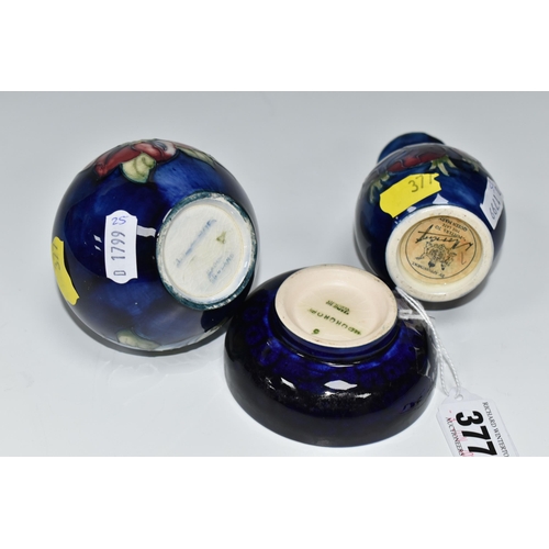 377 - THREE SMALL PIECES OF BLUE GROUND MOORCROFT POTTERY, comprising a shallow footed bowl decorated with... 